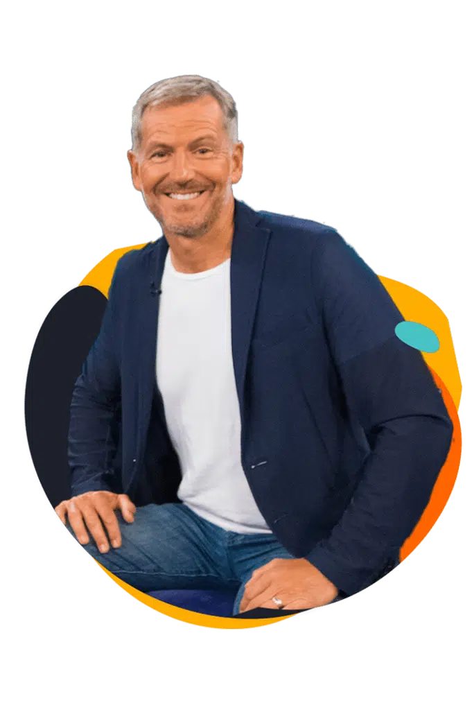 Portraetfoto von John Bevere, laechelnd vor buntem abstraktem Hintergrund